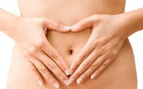 Woman making a heart shape with her hands over her belly button. Get help with constipation