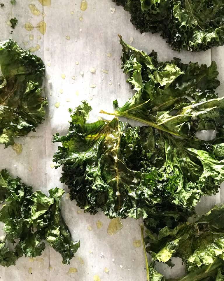Close up of kale leafs in small pieces on parchment paper