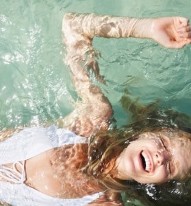 A woman laying on her back swimming in a pool