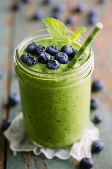 Green smoothie topped with blueberries